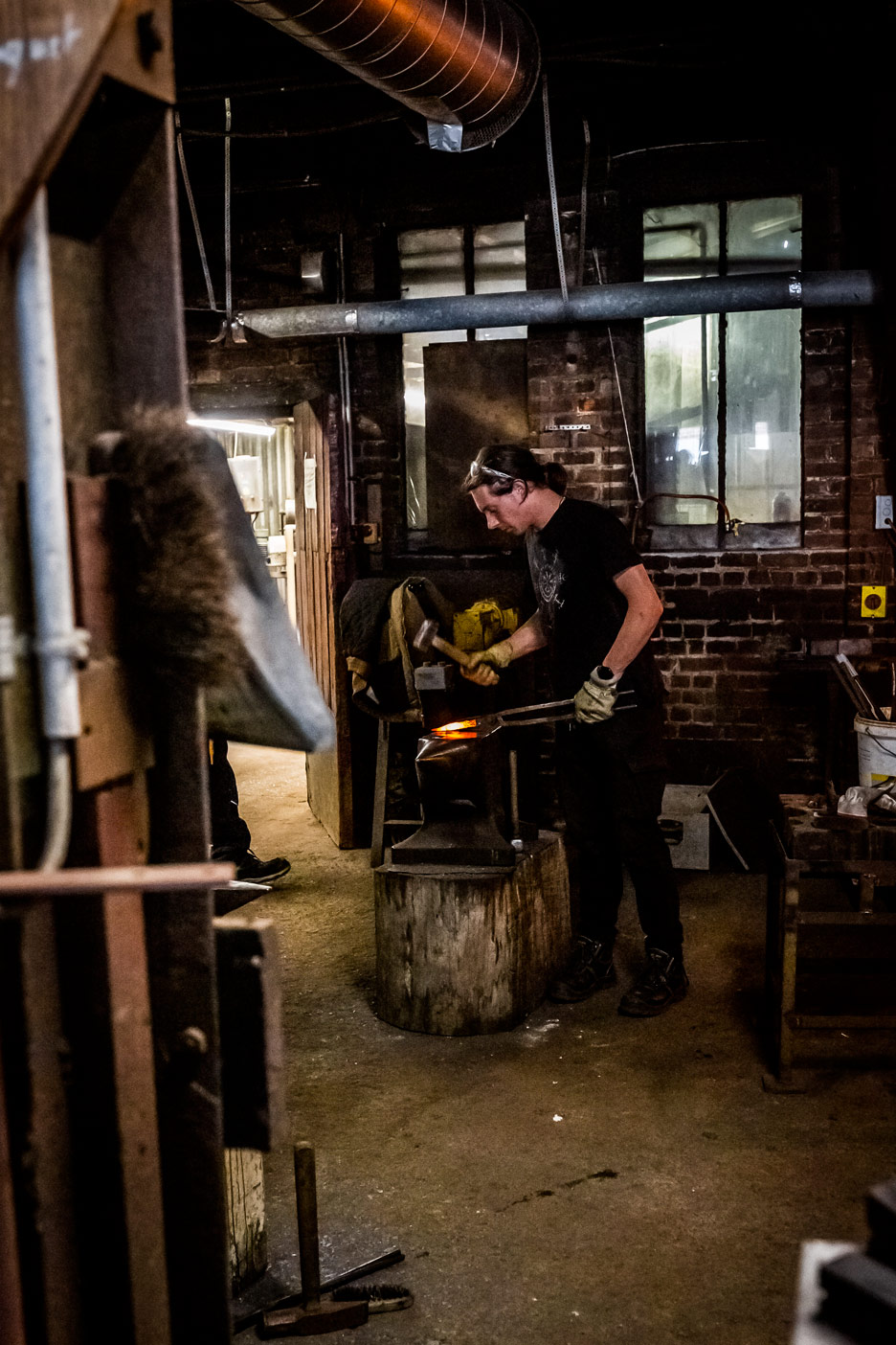 Jeune forgeron travaillant le métal incandescent sur l'enclume