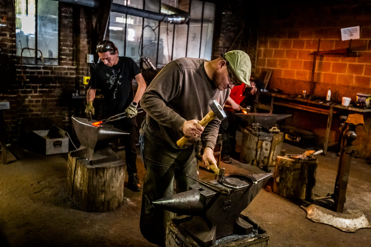 Deux stagiaires forgeant ensemble lors d'un stage de coutellerie