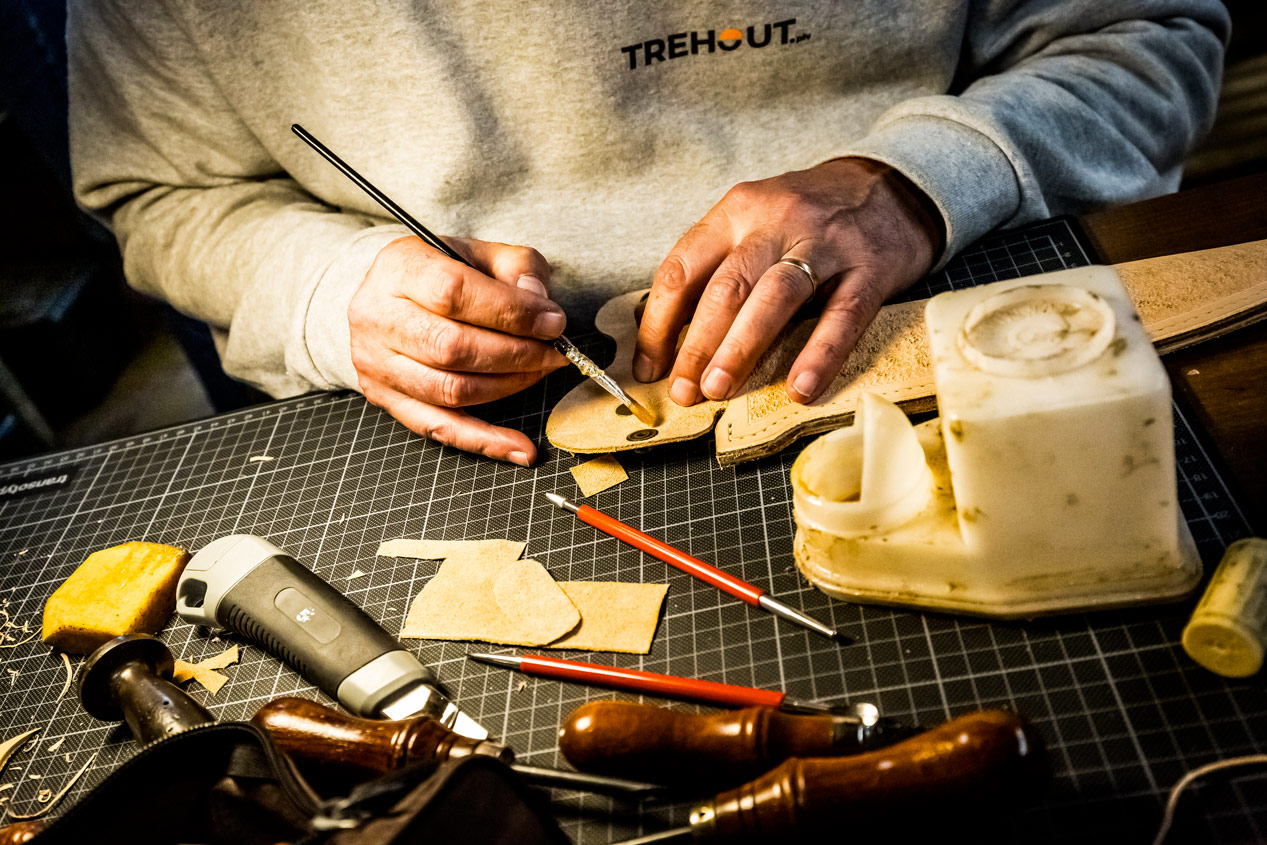 Mains d'artisan travaillant un fourreau en cuir naturel
